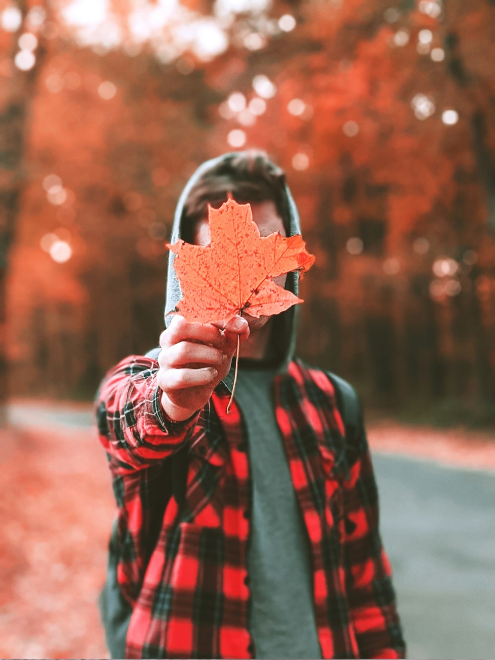 a man holding a leaf in front of his face