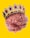 A human brain is depicted wearing a jeweled crown adorned with large red gemstones against a bright yellow background.