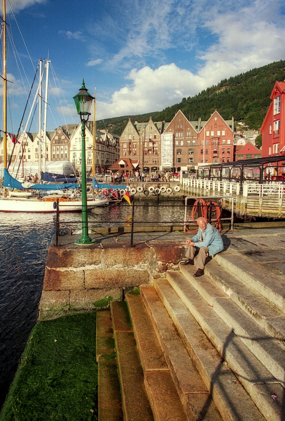 a man sitting on steps next to a body of water