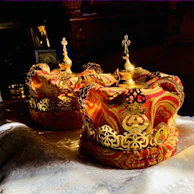 An elegant bronze ceremonial crown resting on ivory silk, reflecting Yoruba royal craftsmanship.