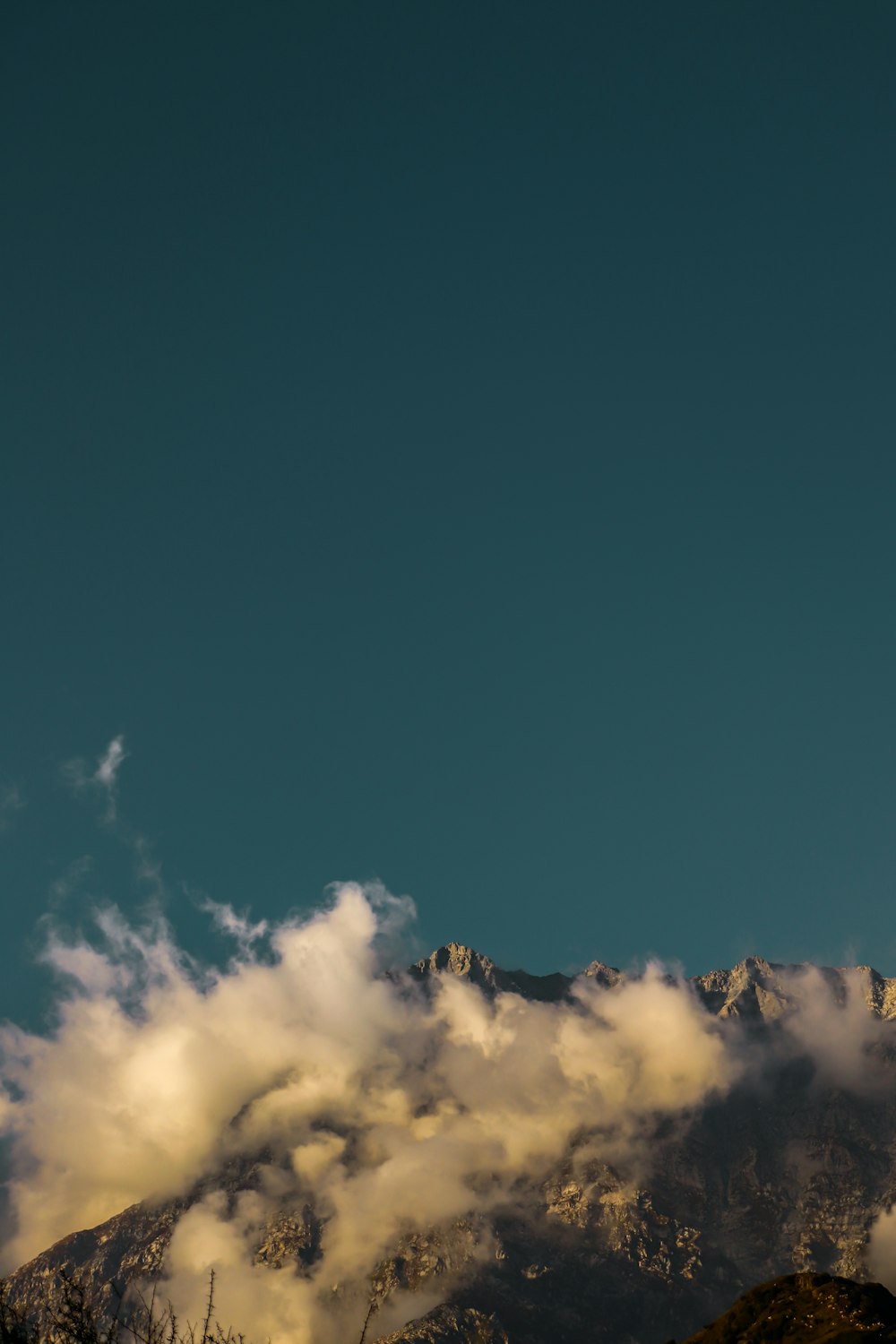 a plane flying over a mountain covered in clouds