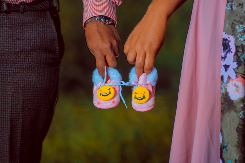 a close up of two people holding onto slippers