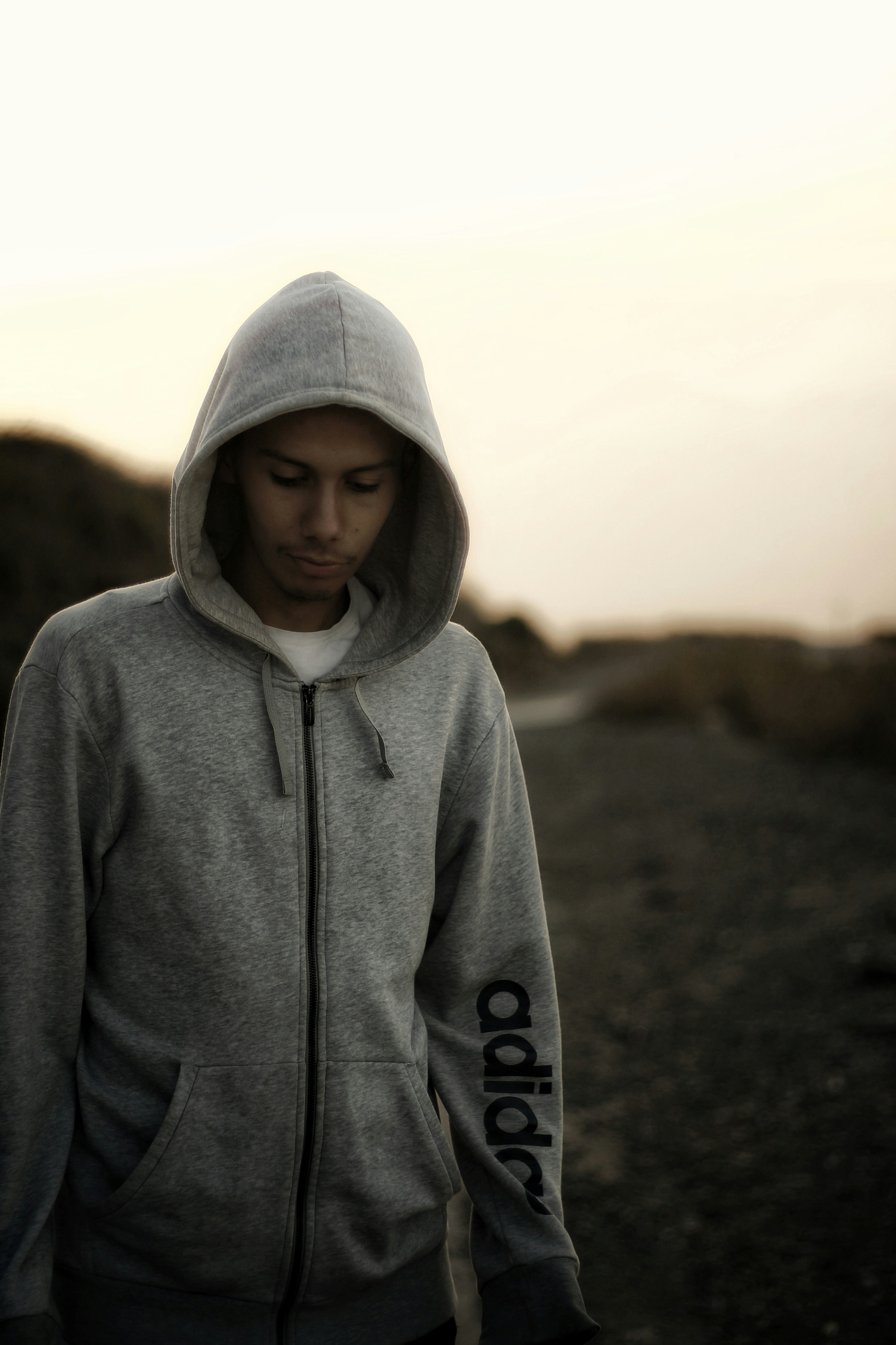 a man in a hoodie is walking down the road