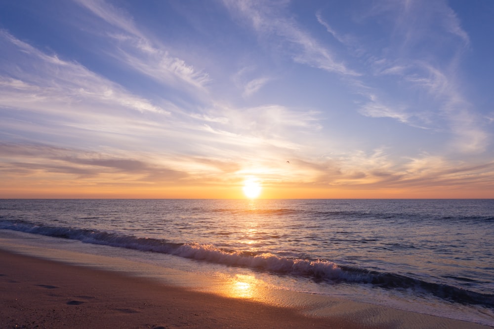 Le soleil se couche sur l’océan sur la plage