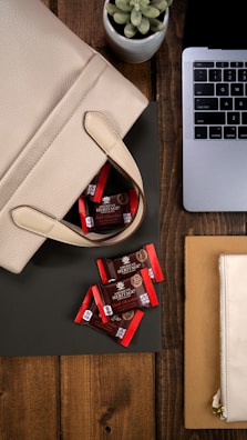 A stylish workspace with a bagnest bag next to the desk, storing cables and tech accessories.