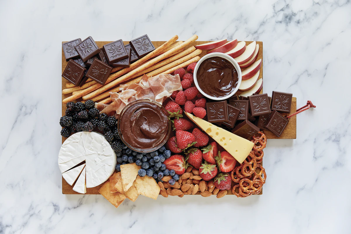 Cheese and cracker skewers arranged on a wooden board with fresh strawberries