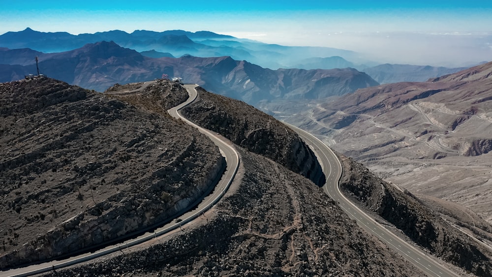 an aerial view of a winding road in the mountains