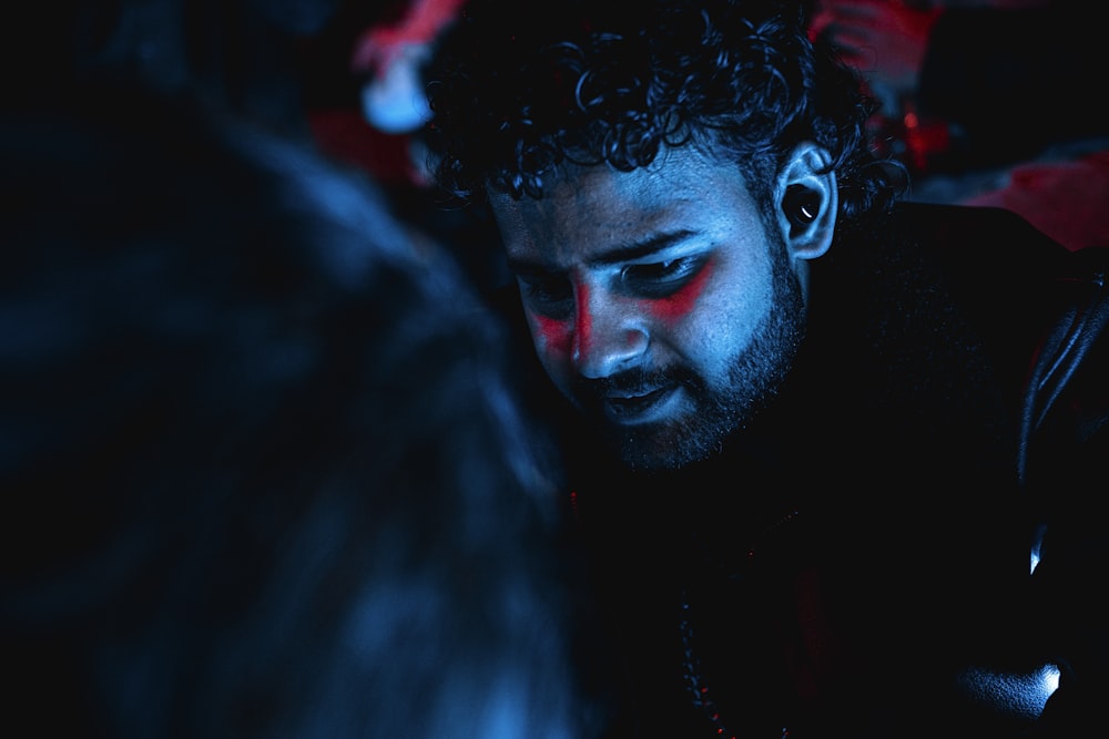 a man in a dark room looking at his cell phone