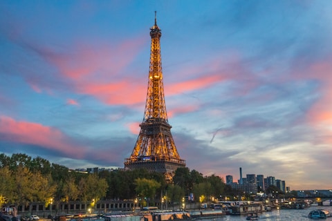 the eiffel tower is lit up at night