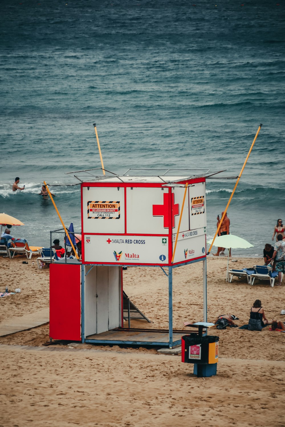 a lifeguard station on the beach with people in the water