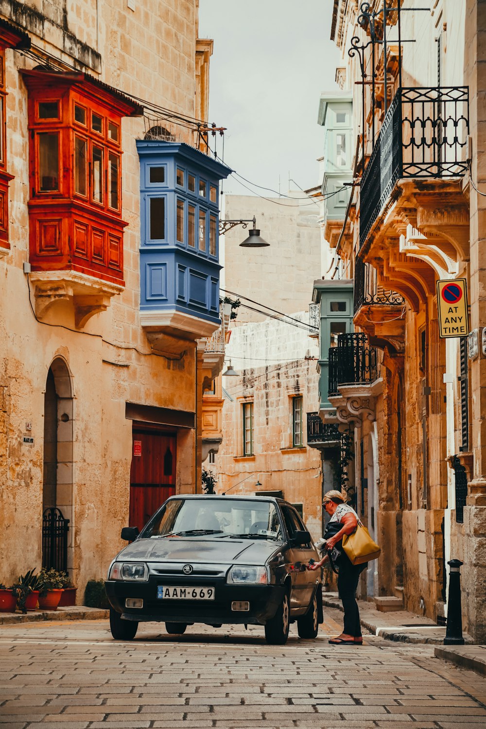 a car parked on the side of a street next to a building