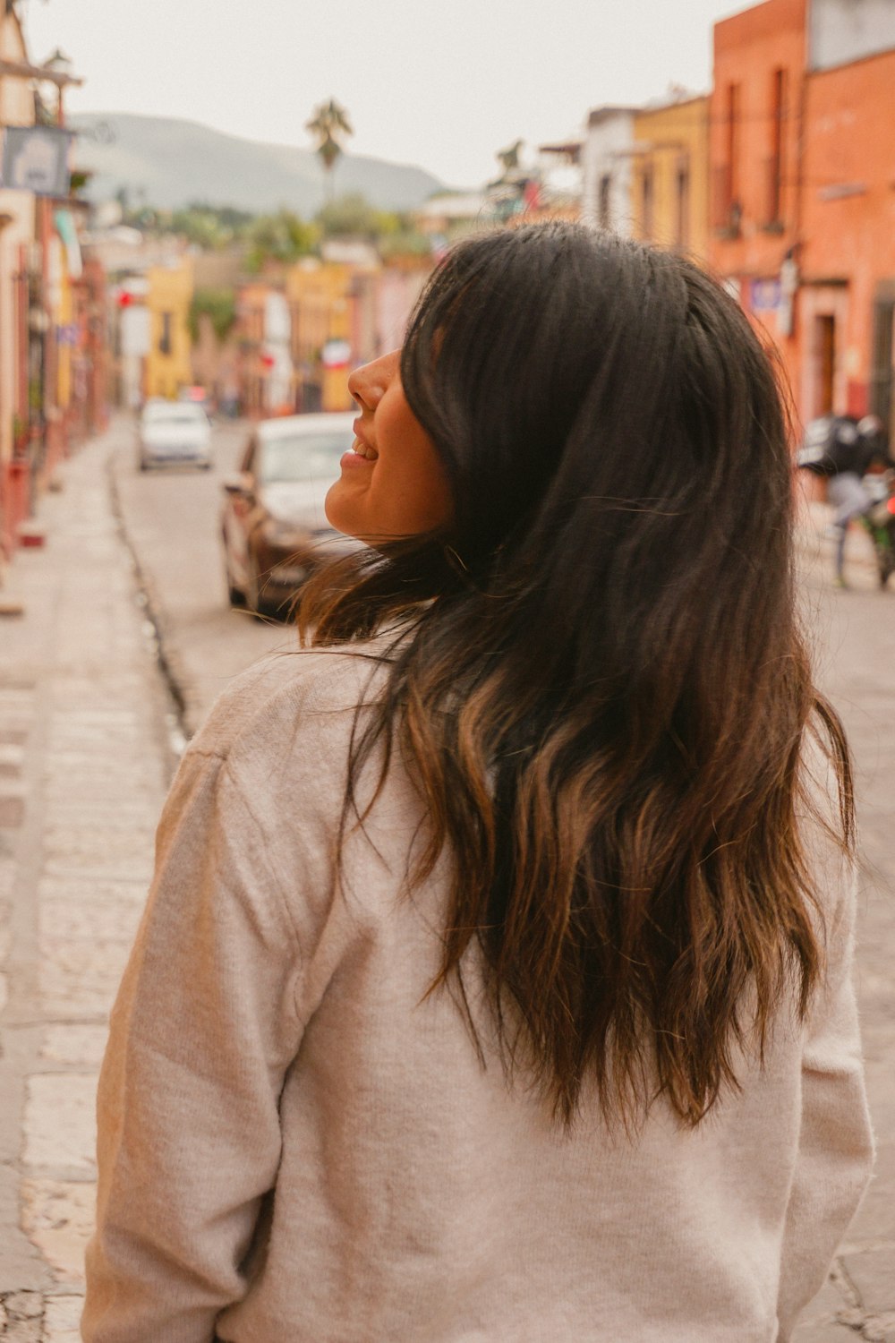 a woman standing on the side of a street