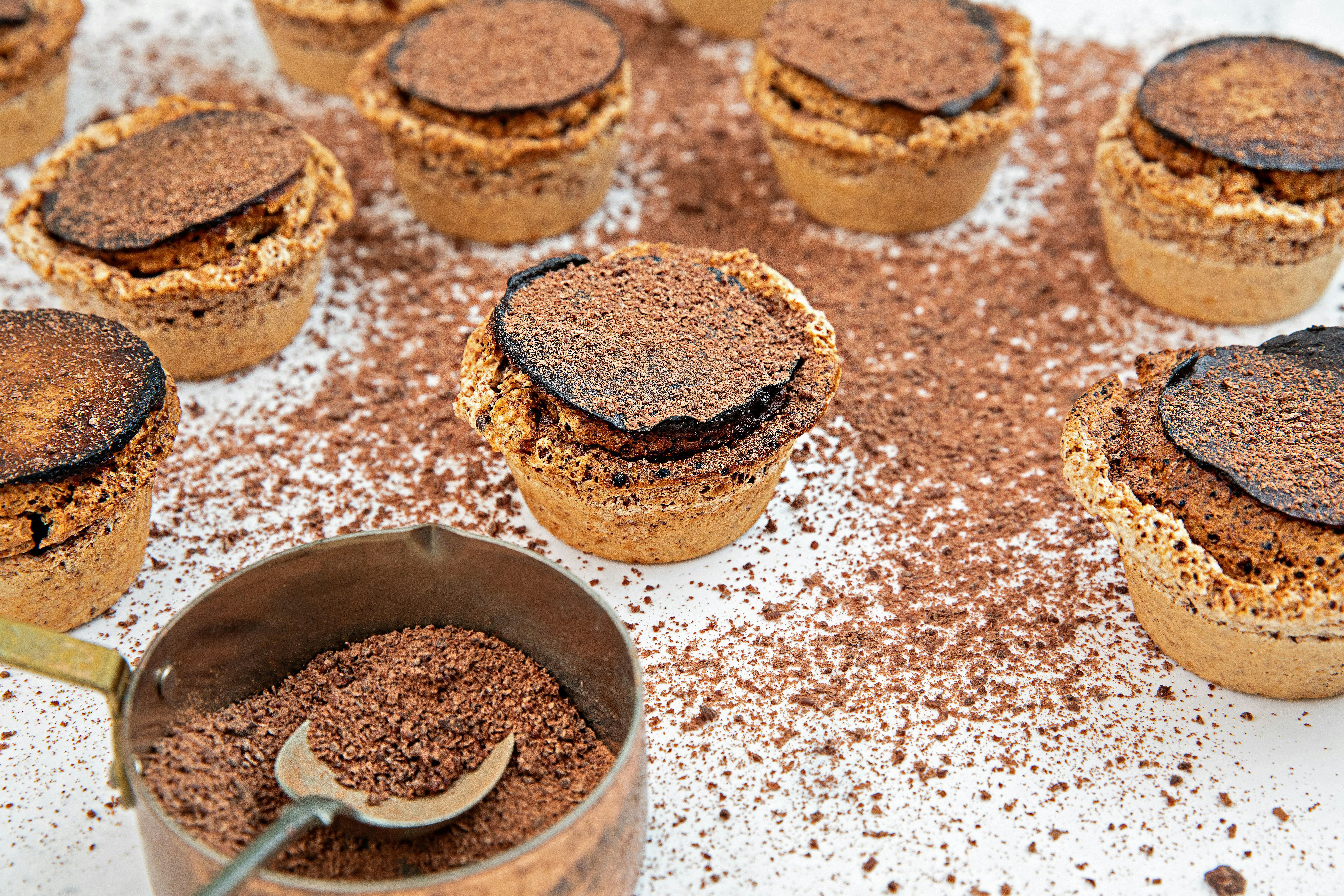 a table topped with lots of cupcakes covered in chocolate