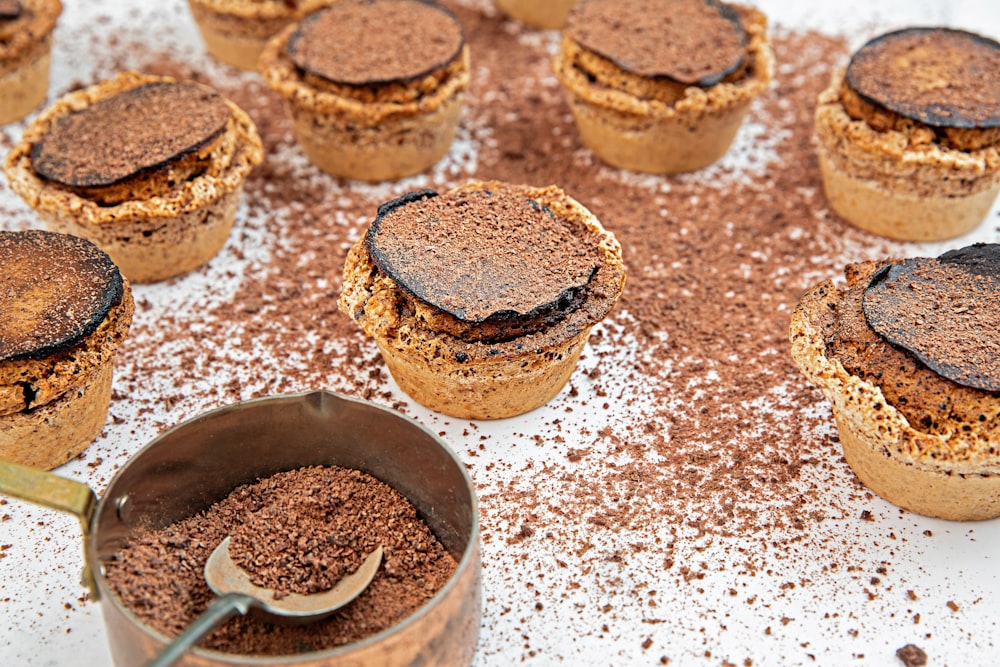 a table topped with lots of cupcakes covered in chocolate