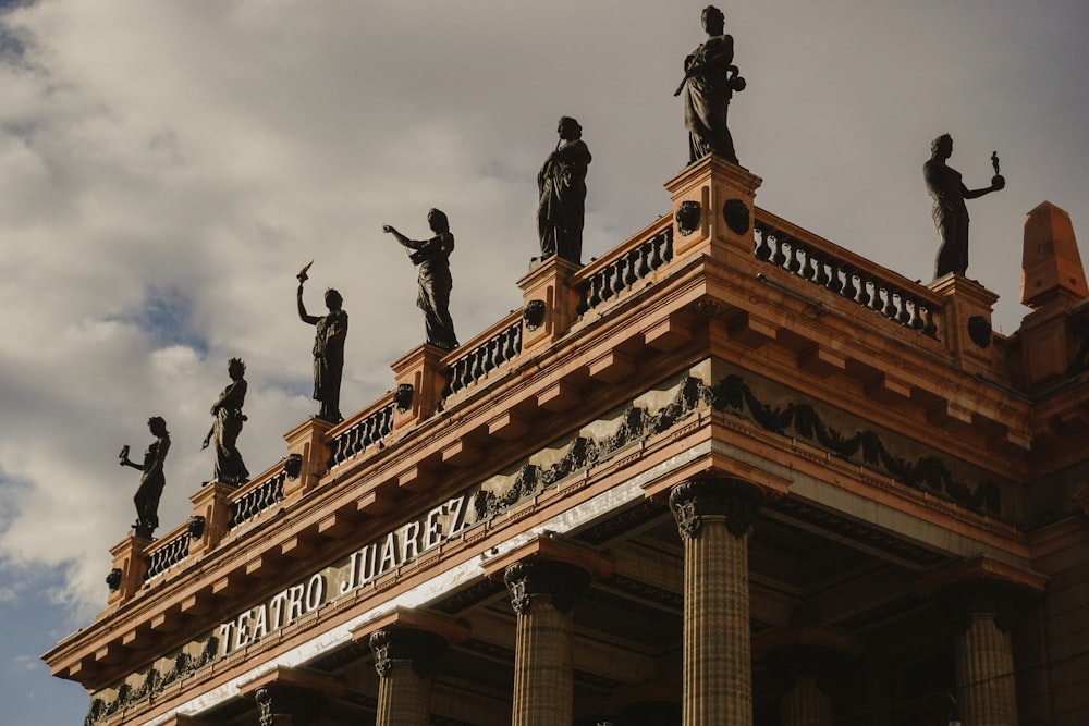 a tall building with statues on top of it