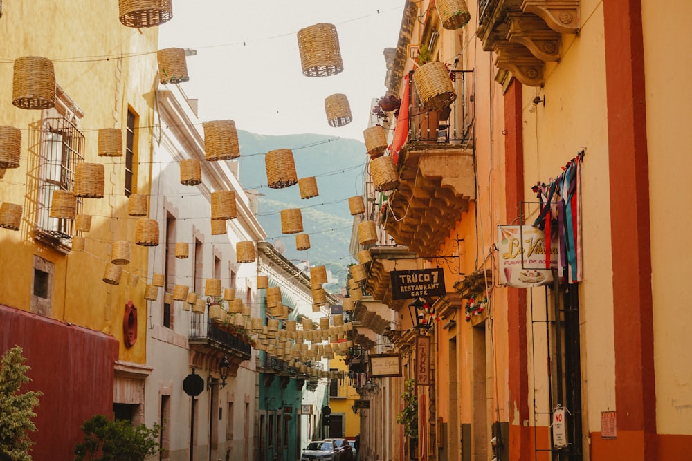 a narrow street with many hanging baskets on the buildings