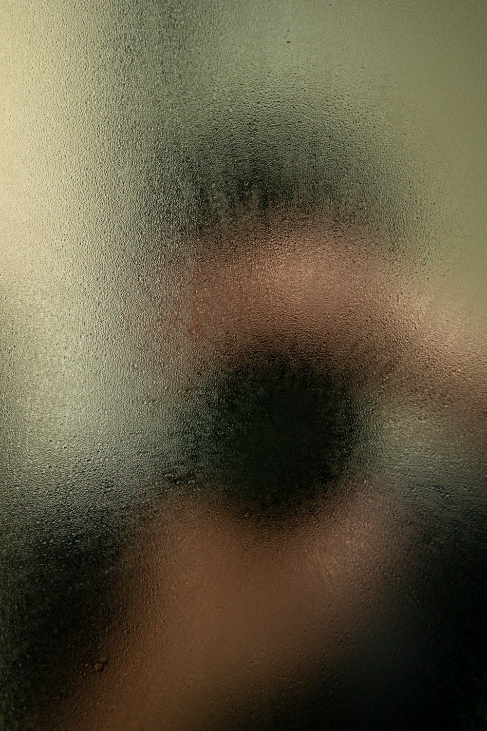 a blurry image of a person's face behind a frosted glass door
