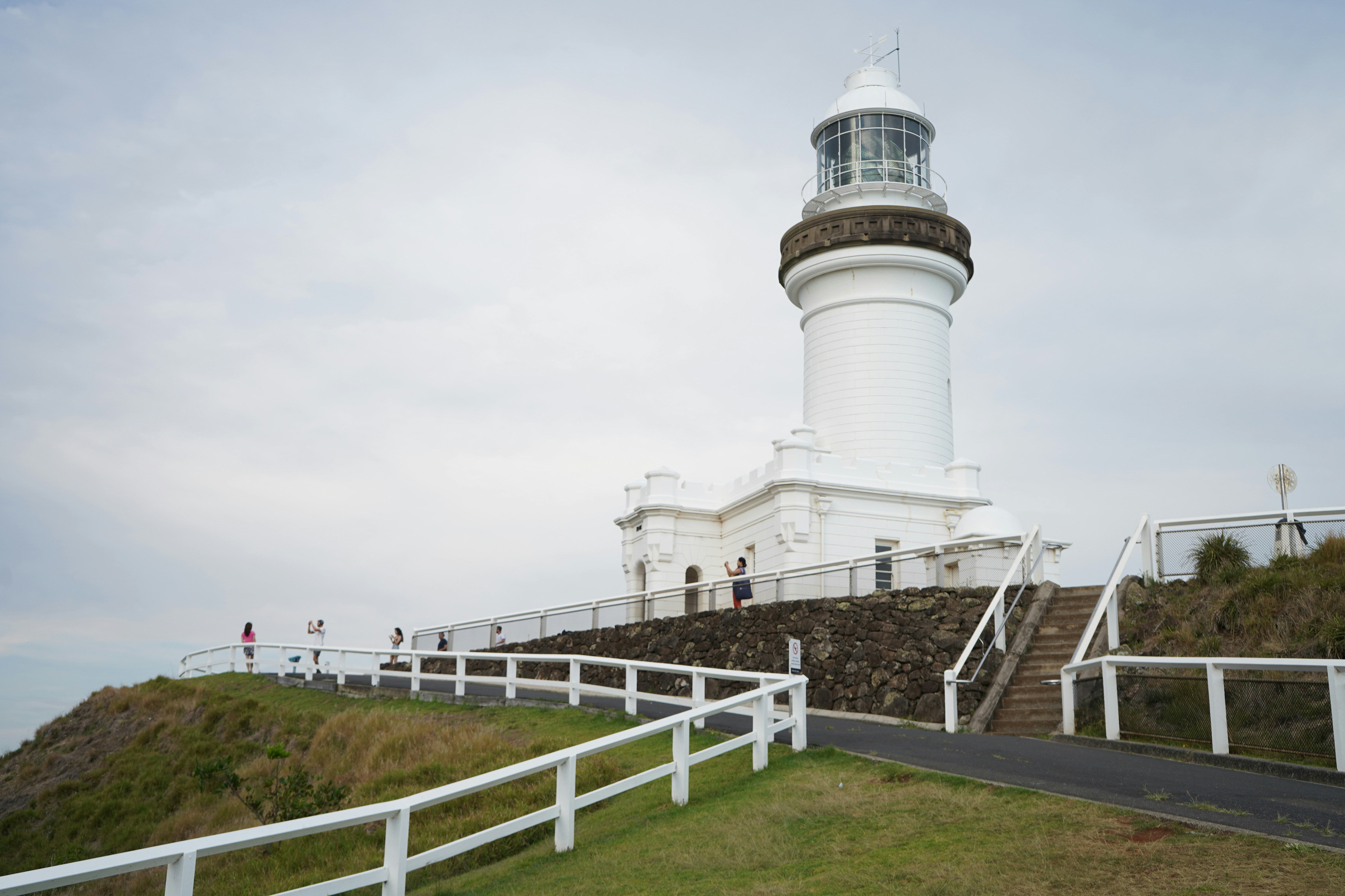 a white lighthouse on top of a hill