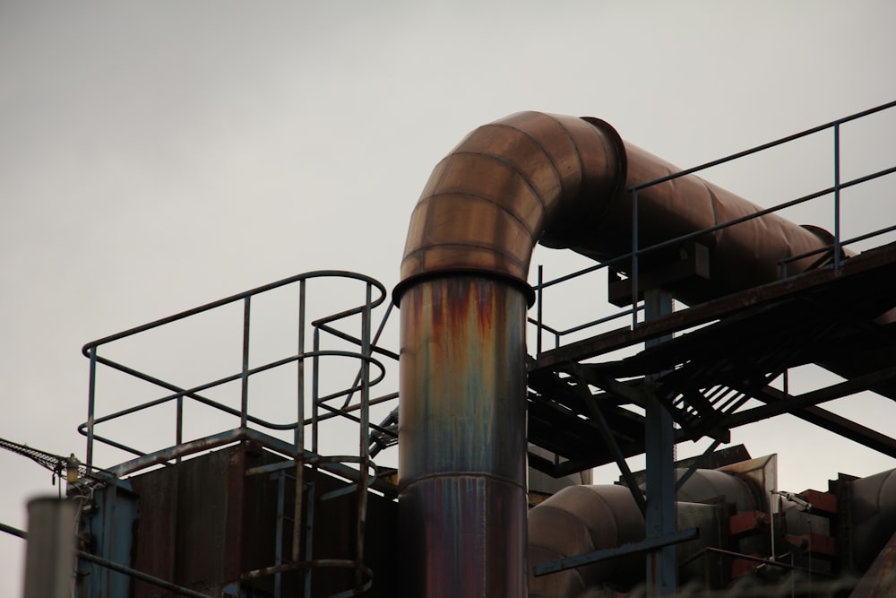 a metal pipe with rust on it near a building