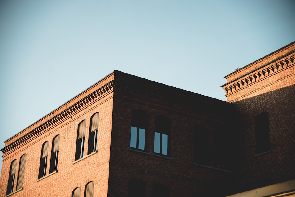 a tall brick building with a clock on the top of it