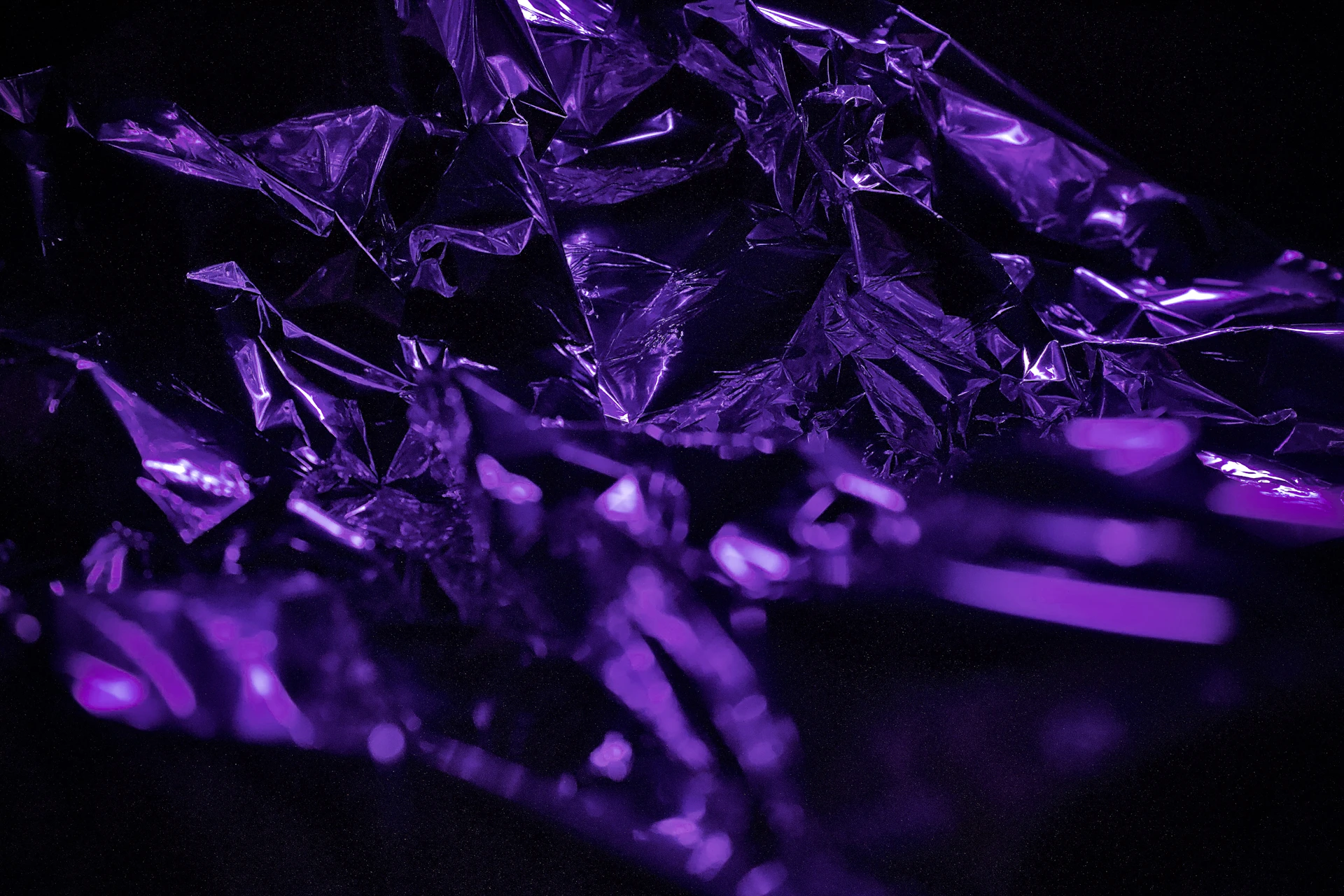 a bunch of shiny purple diamonds on a black background