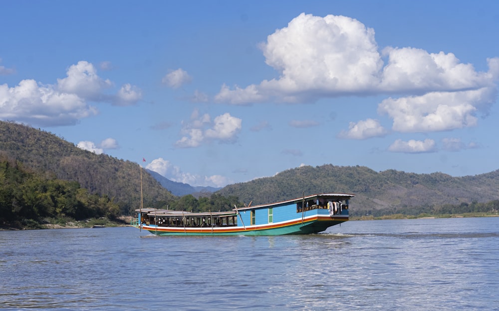 a blue and white boat floating on top of a lake