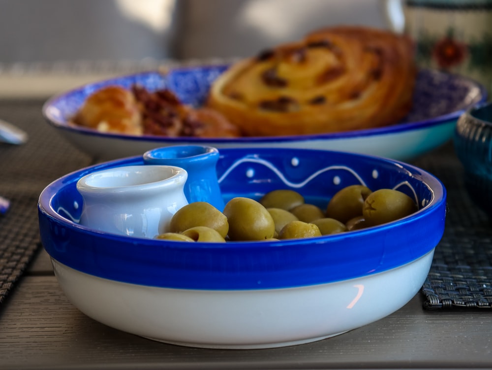 un tazón de aceitunas y un tazón de pan en una mesa