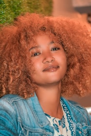 a woman with red curly hair is smiling