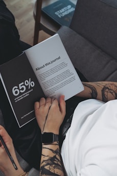 a person sitting on a couch reading a book