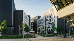 Modern campus buildings with patterned facades along a paved walkway
