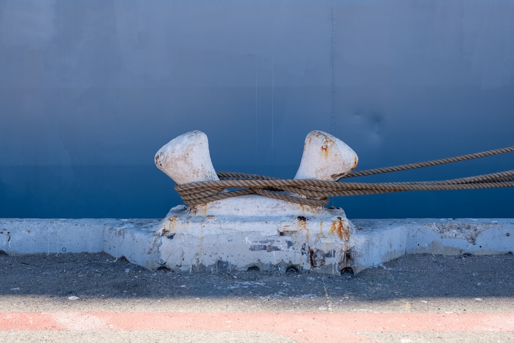 a rusted metal object with a rope attached to it