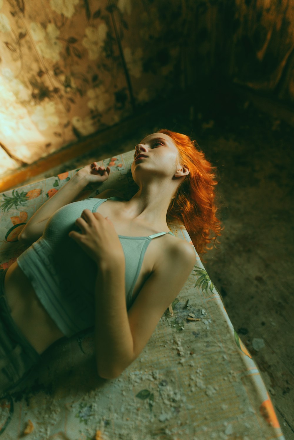 a woman with red hair laying on a bed
