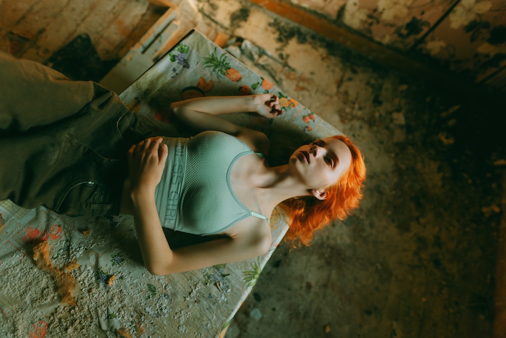 a woman with red hair laying on the ground