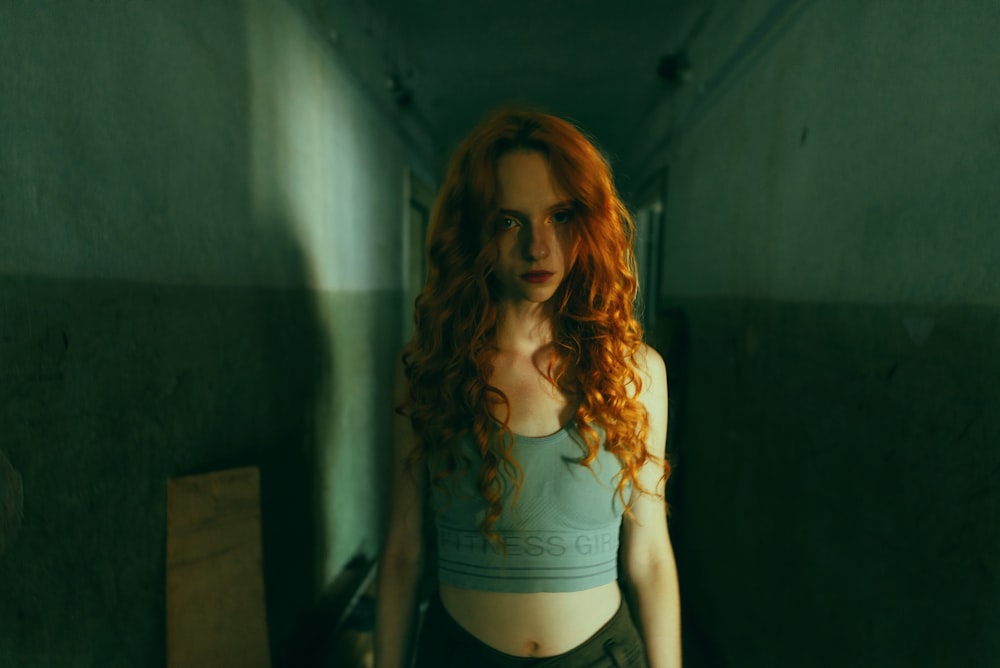 a woman with red hair standing in a hallway