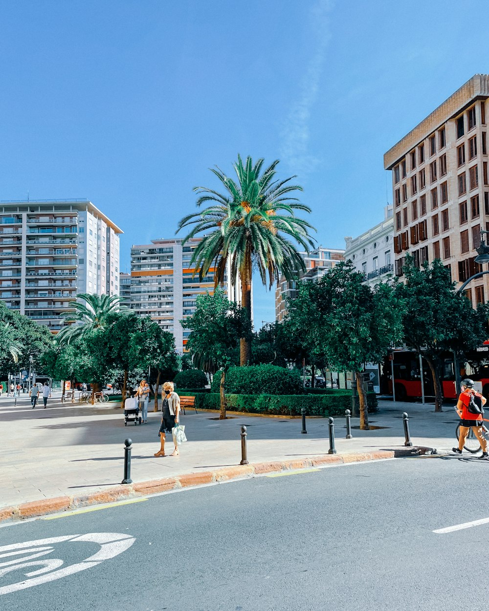 a group of people walking down a street next to tall buildings