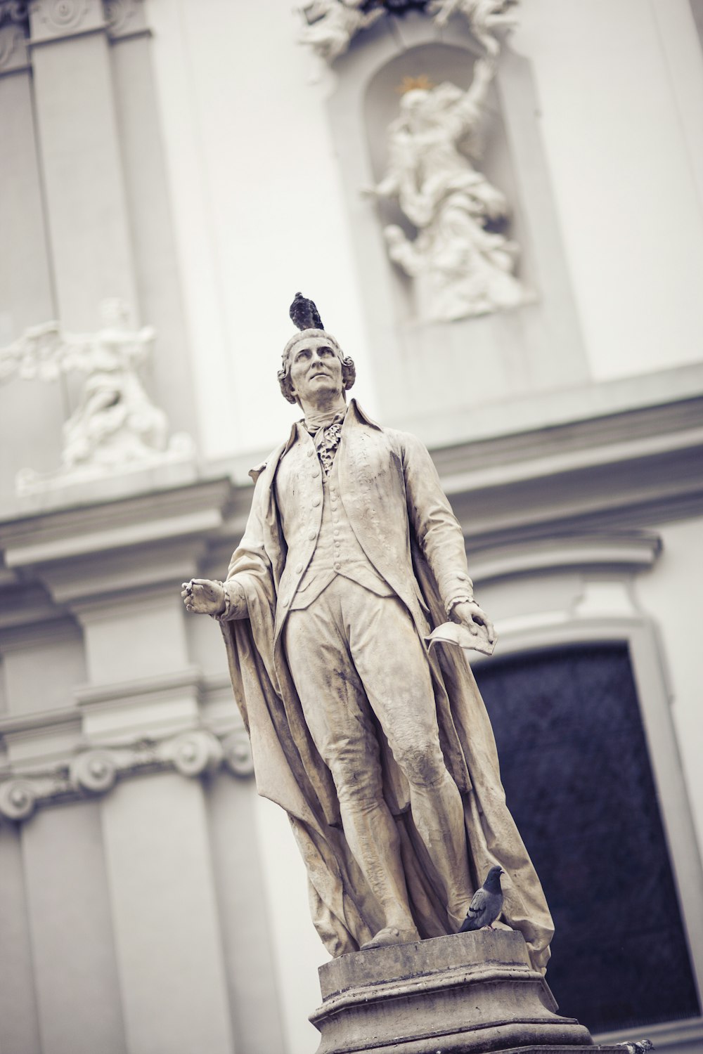 a statue of a man standing in front of a building