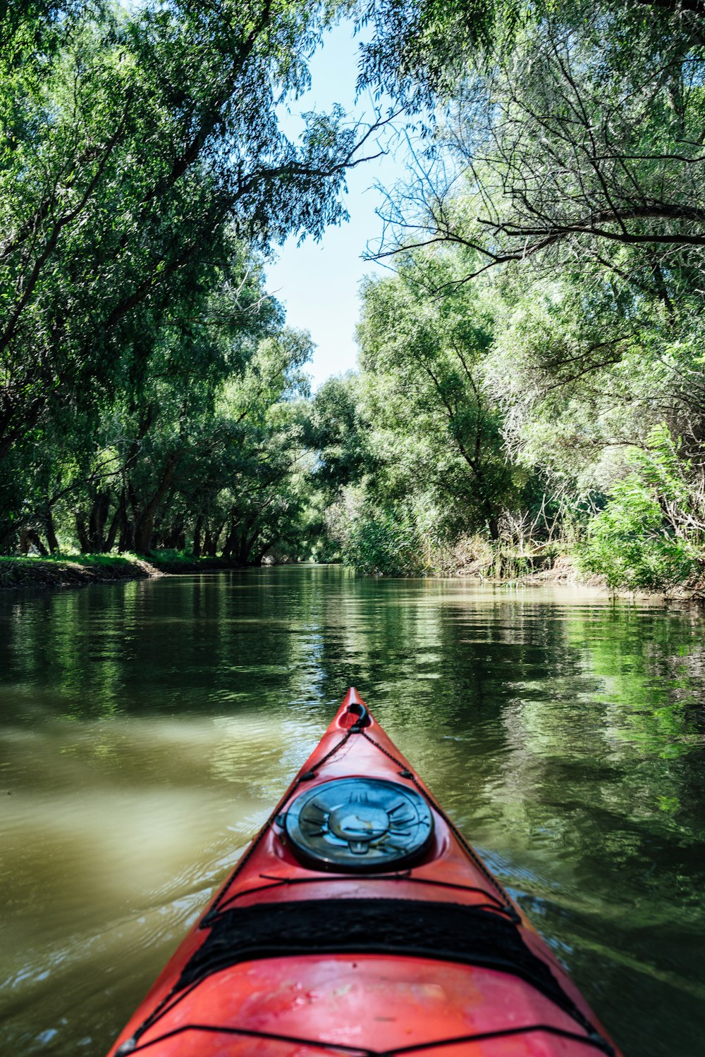 a red kayak in the middle of a river