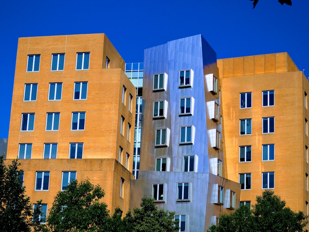 a tall building with many windows next to trees