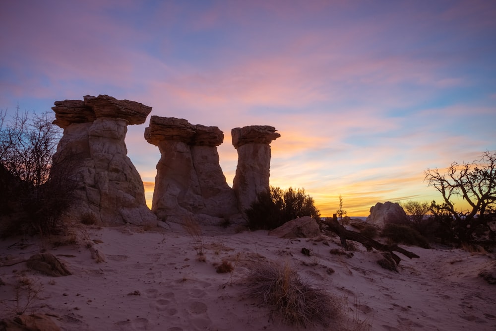 Un gruppo di formazioni rocciose nel deserto al tramonto