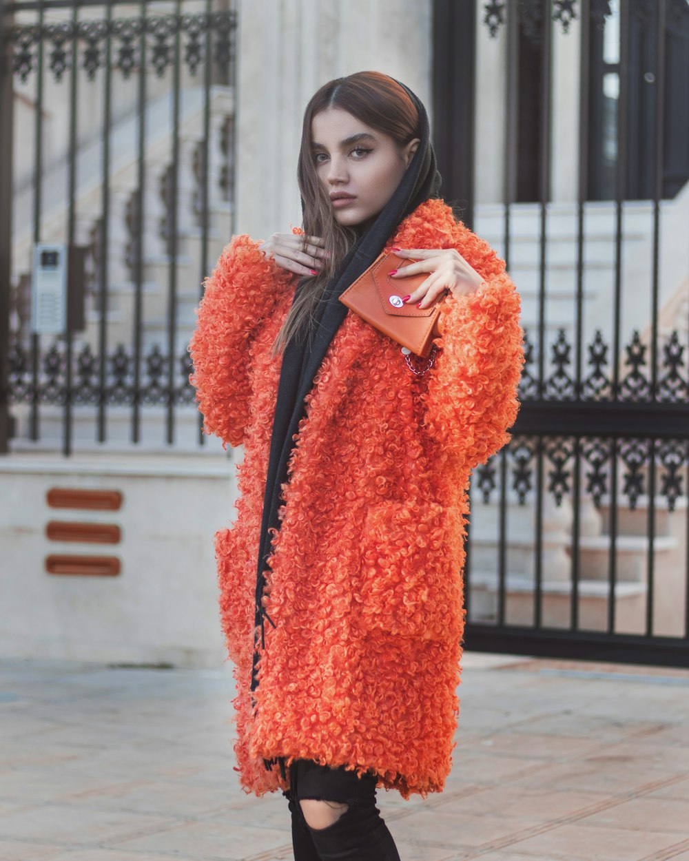 a woman in an orange fuzzy coat and black boots