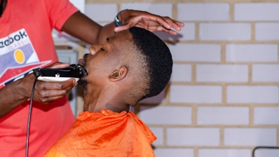 a man getting his hair cut at a barber shop