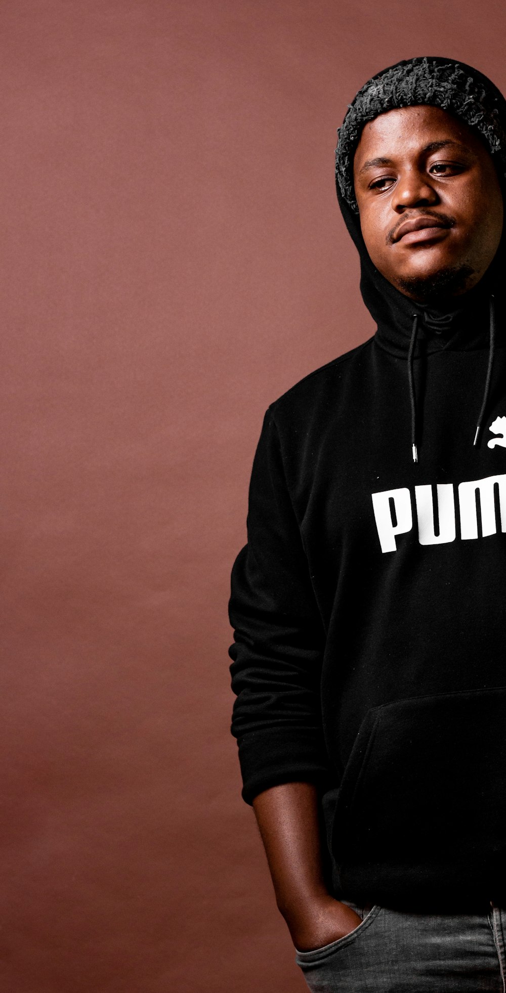 a man wearing a black hoodie with the word puma on it