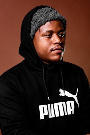 a man wearing a black hoodie with a puma logo on it