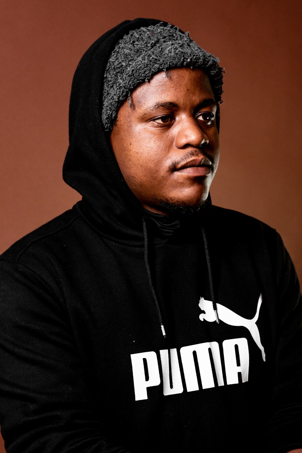 a man wearing a black hoodie with a puma logo on it