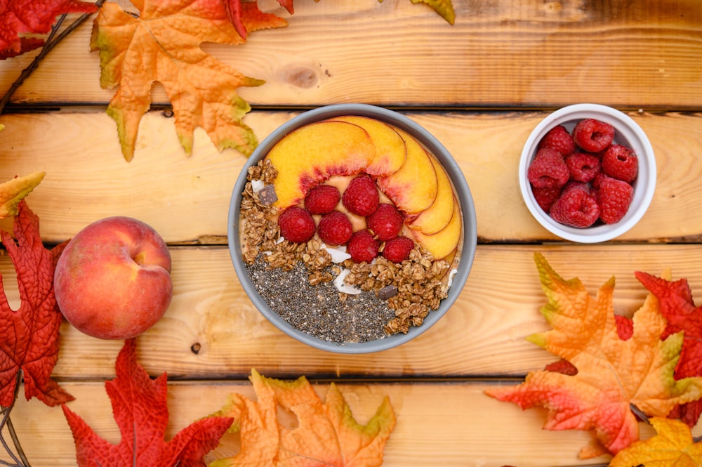 a bowl of granola with raspberries and peaches