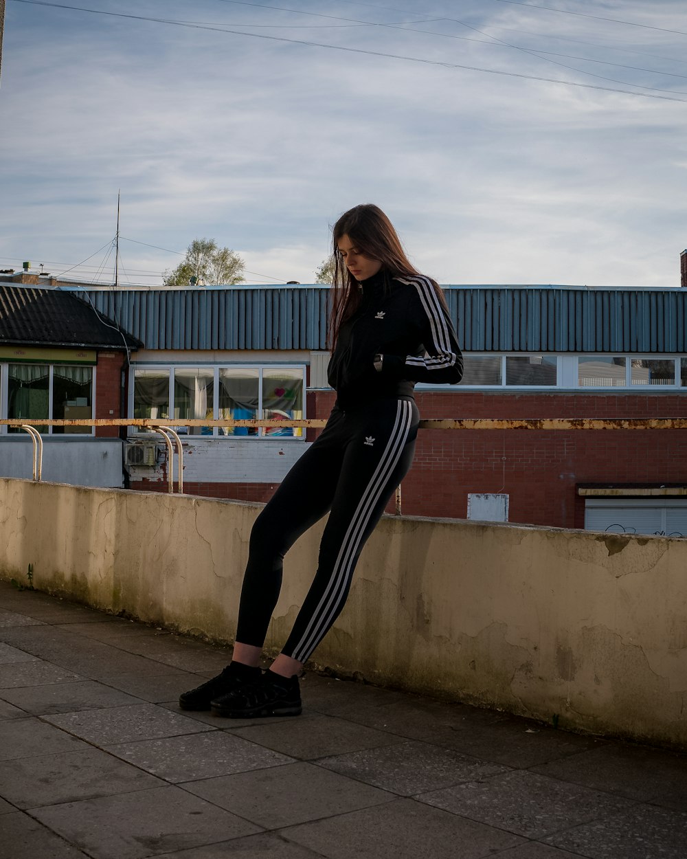 a woman leaning against a wall with her leg up