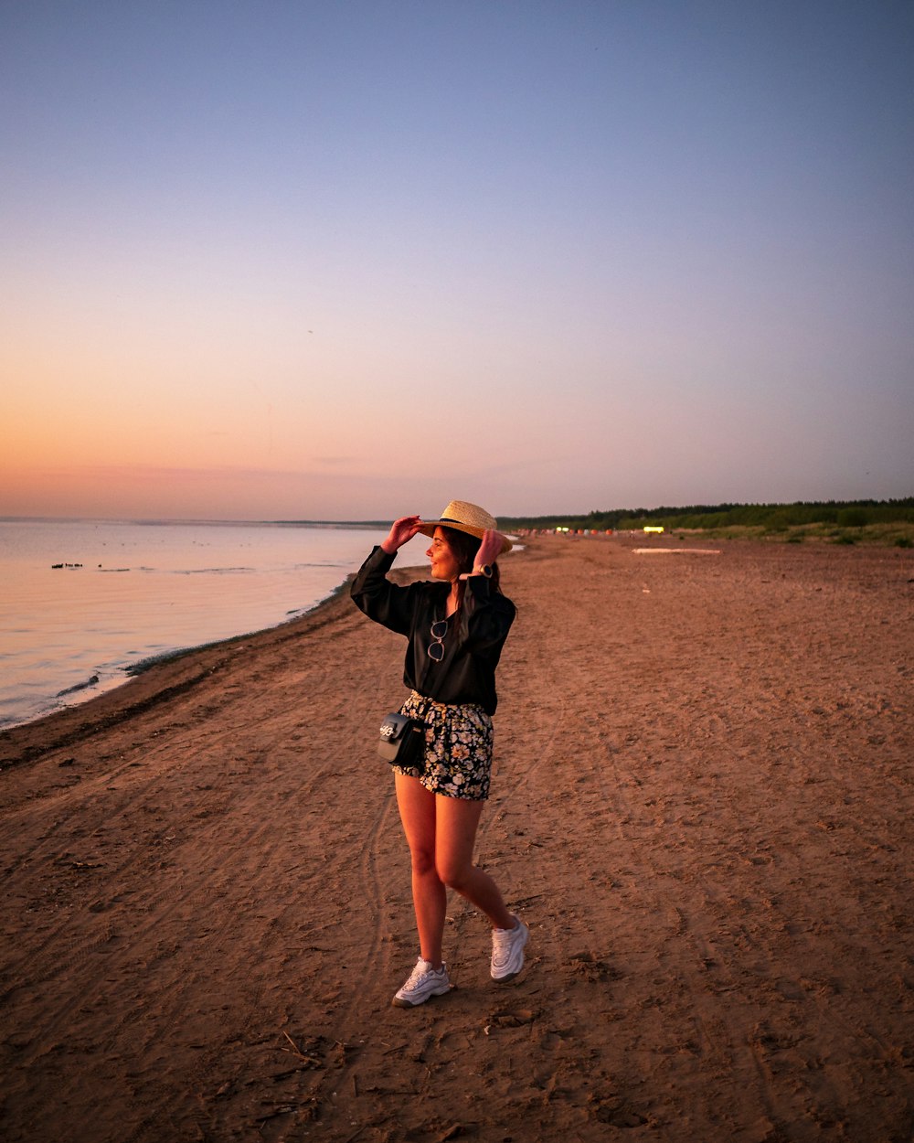 a woman standing on top of a sandy beach