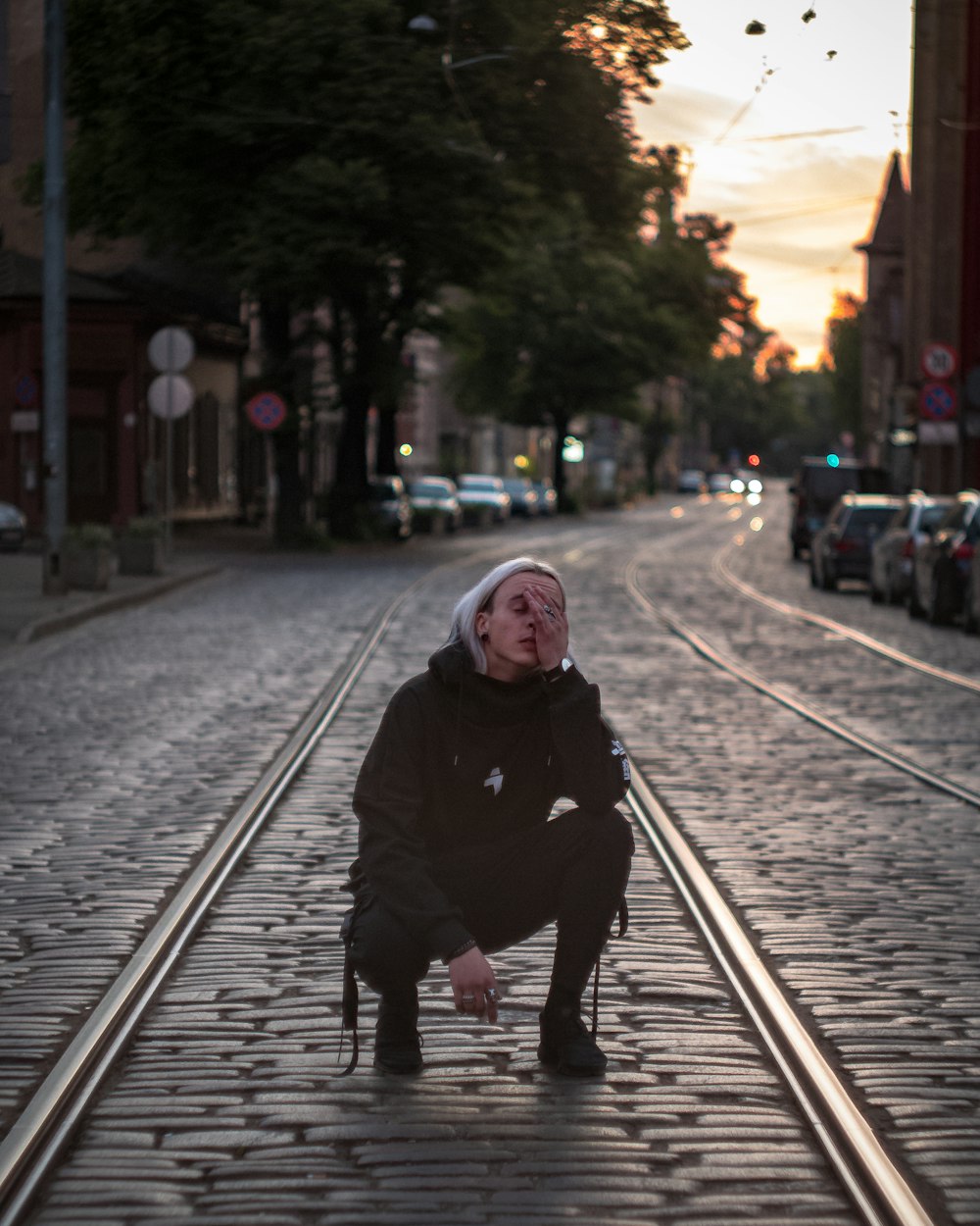 a person kneeling down on a train track