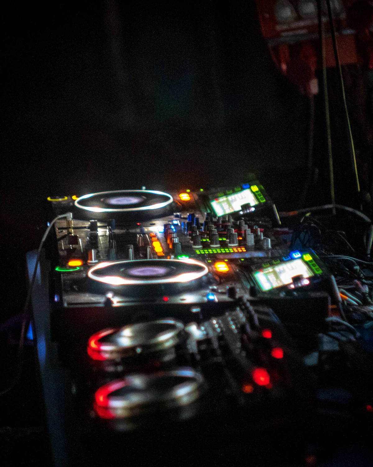 A DJ's turntable lit in a dark booth