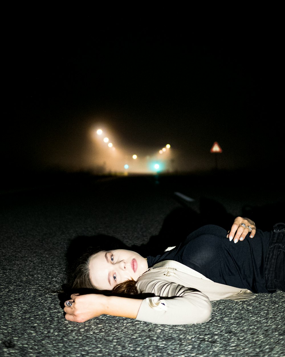a woman laying on the ground in the dark